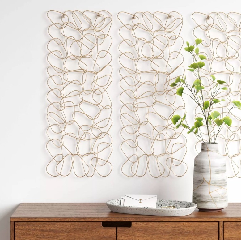 Metal wall art, vase, flowers, credenza.