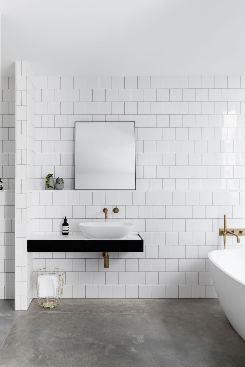 Bathroom with bright white subway tile walls and dark concrete floor