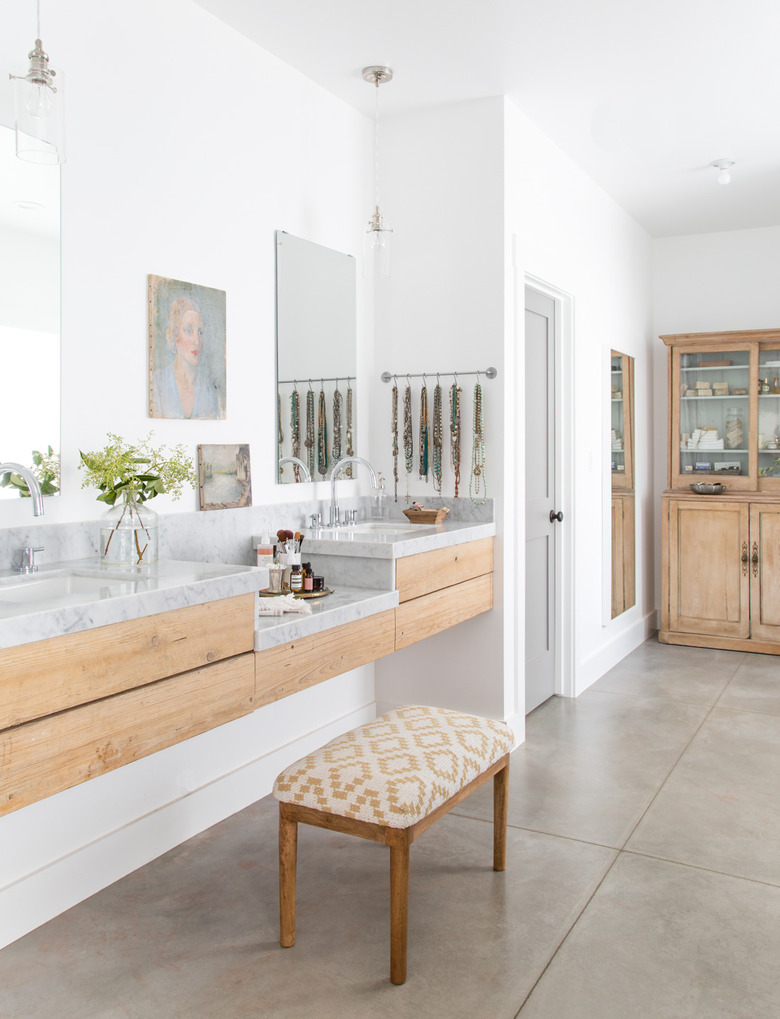 A vanity stool in a minimal bathroom with concrete floor