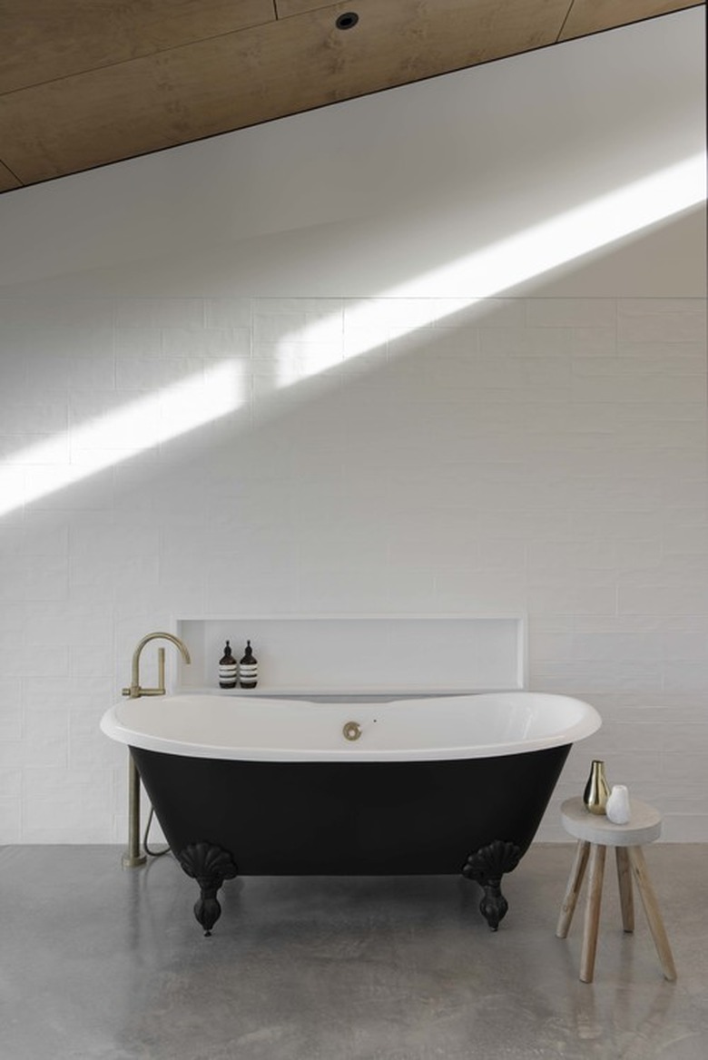 A black bathtub on concrete floors