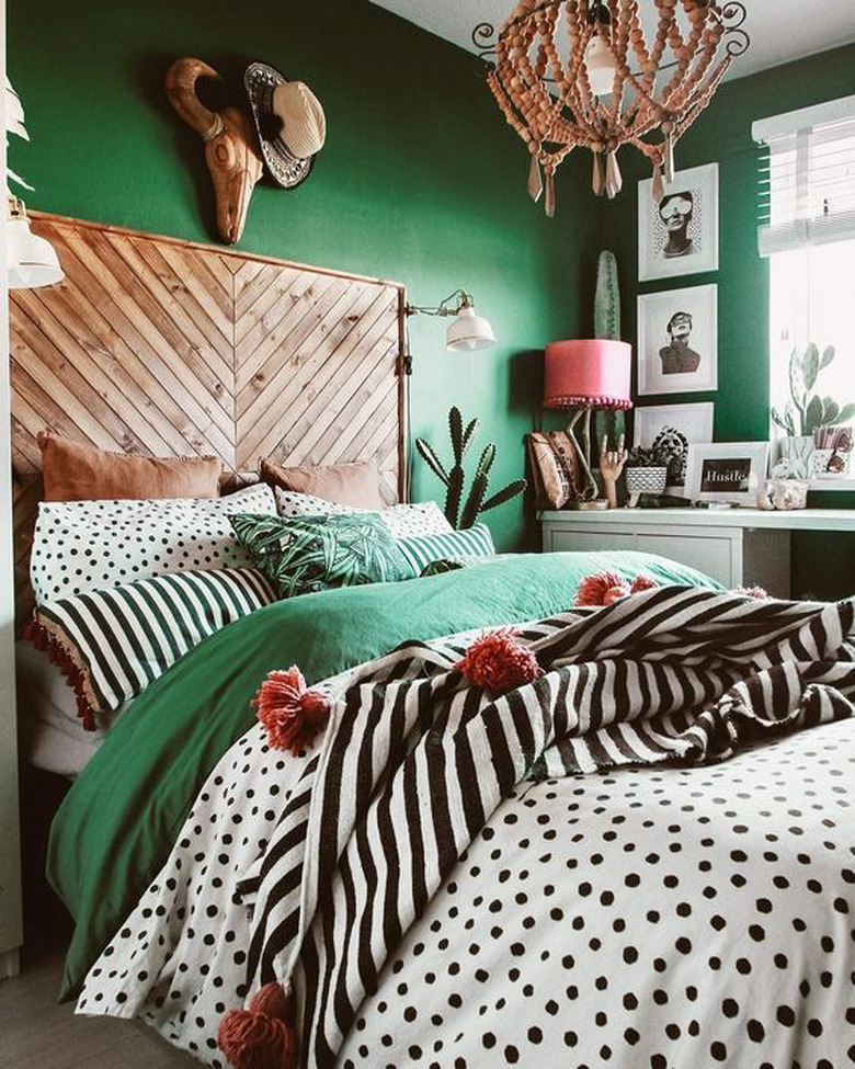 green bedroom with herringbone wood headboard