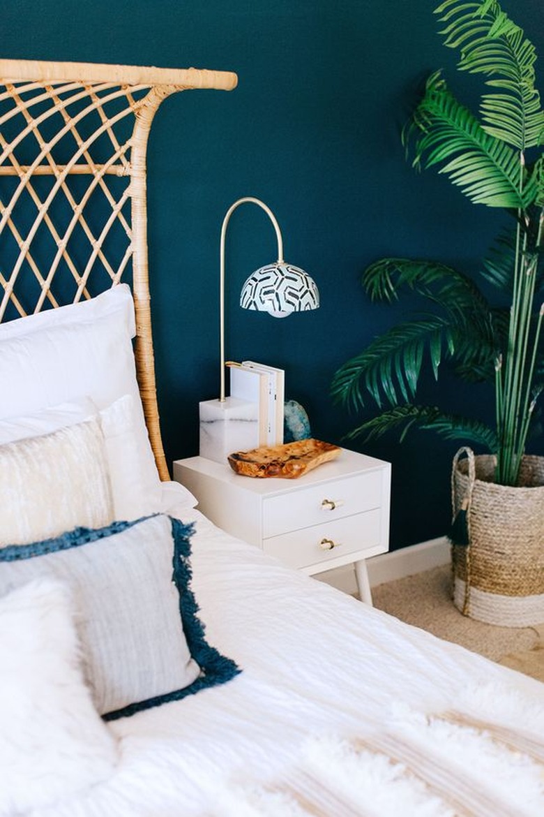 blue-green bedroom with woven headboard and potted plant