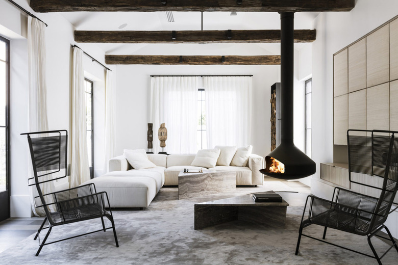 Scandinavian inspired living room with exposed ceiling beams and hanging fireplace