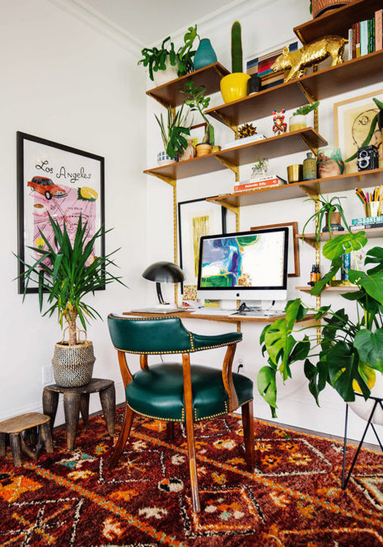 bohemian home office with green chair and red rug