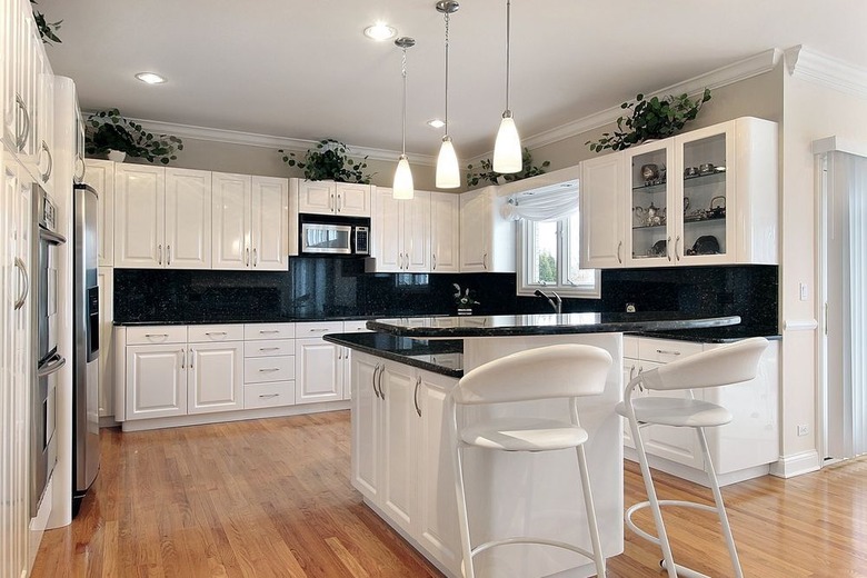 white cabinets, black granite countertops and backsplash, stainless steel appliances