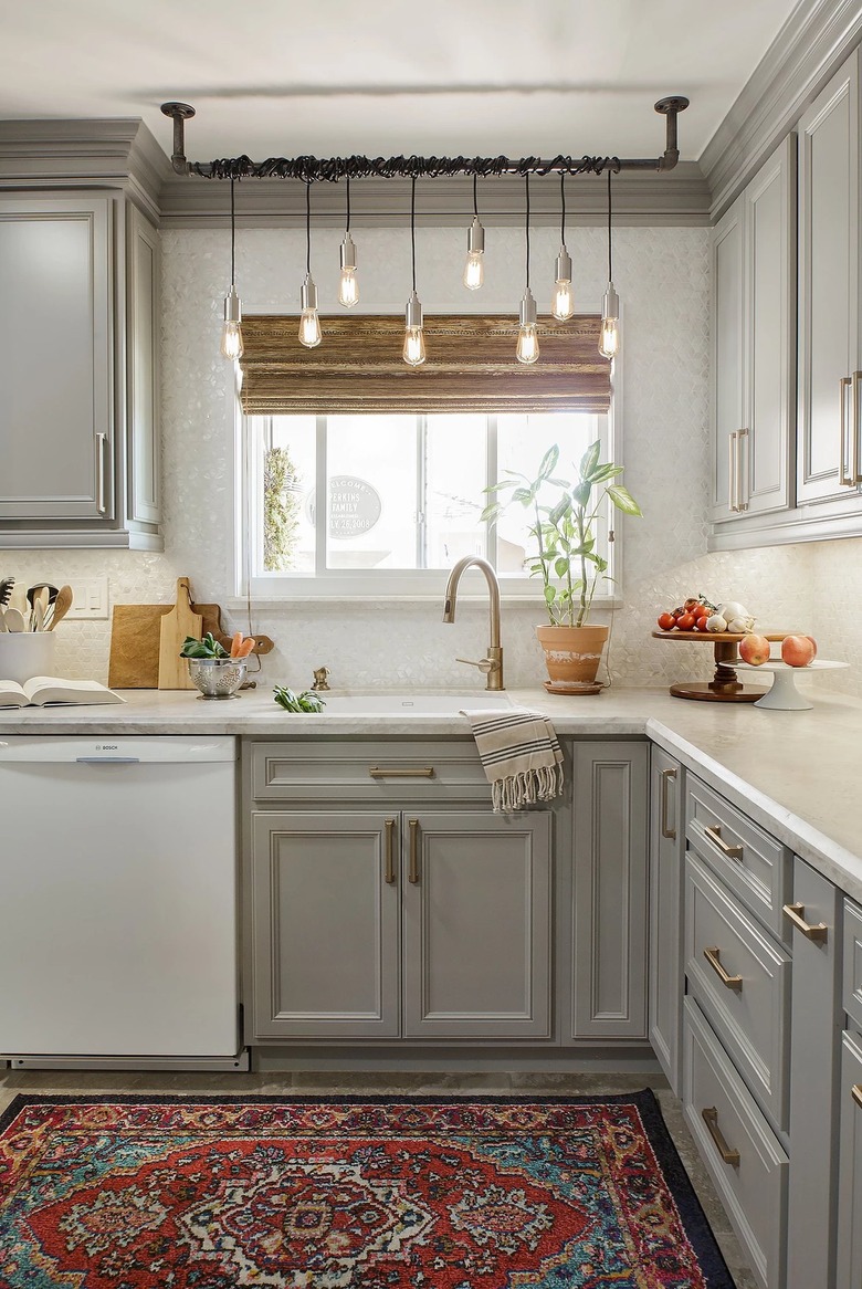 gray and white l-shaped kitchen with chandelier over sink