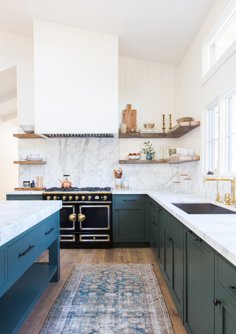 L-shaped kitchen with blue cabinets and marble countertops