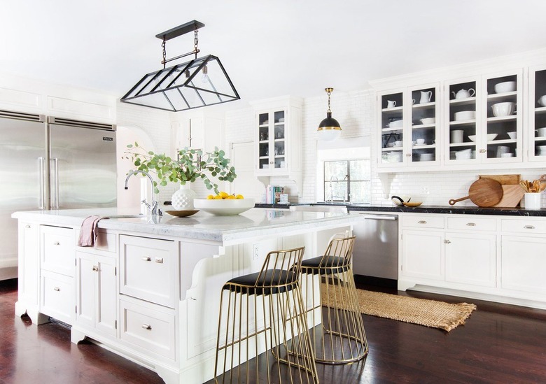 L-shaped kitchen design with white cabinets and black countertops