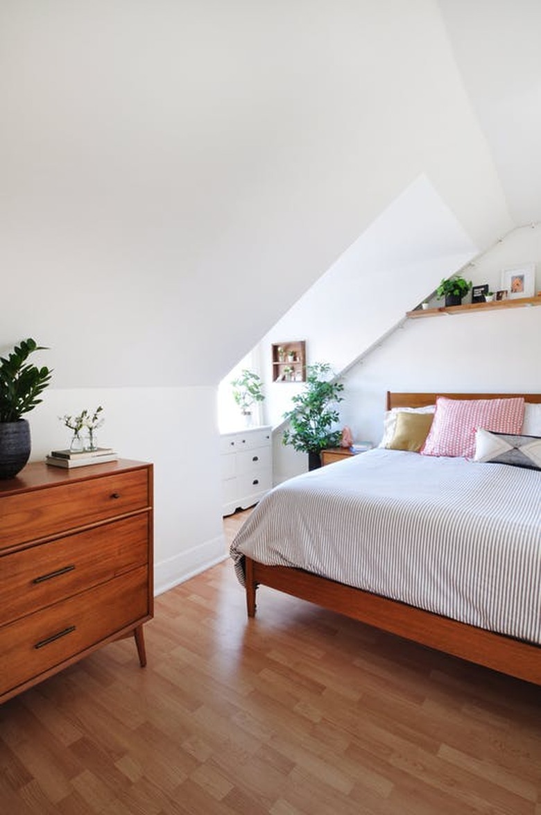 Simple midcentury bedroom with skylight and thinly-striped pillows and blanket