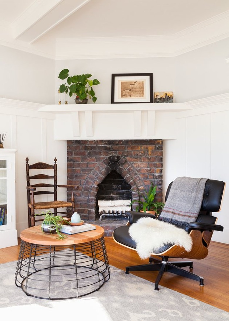 brick fireplace with eclectic vintage chairs and modern coffee table