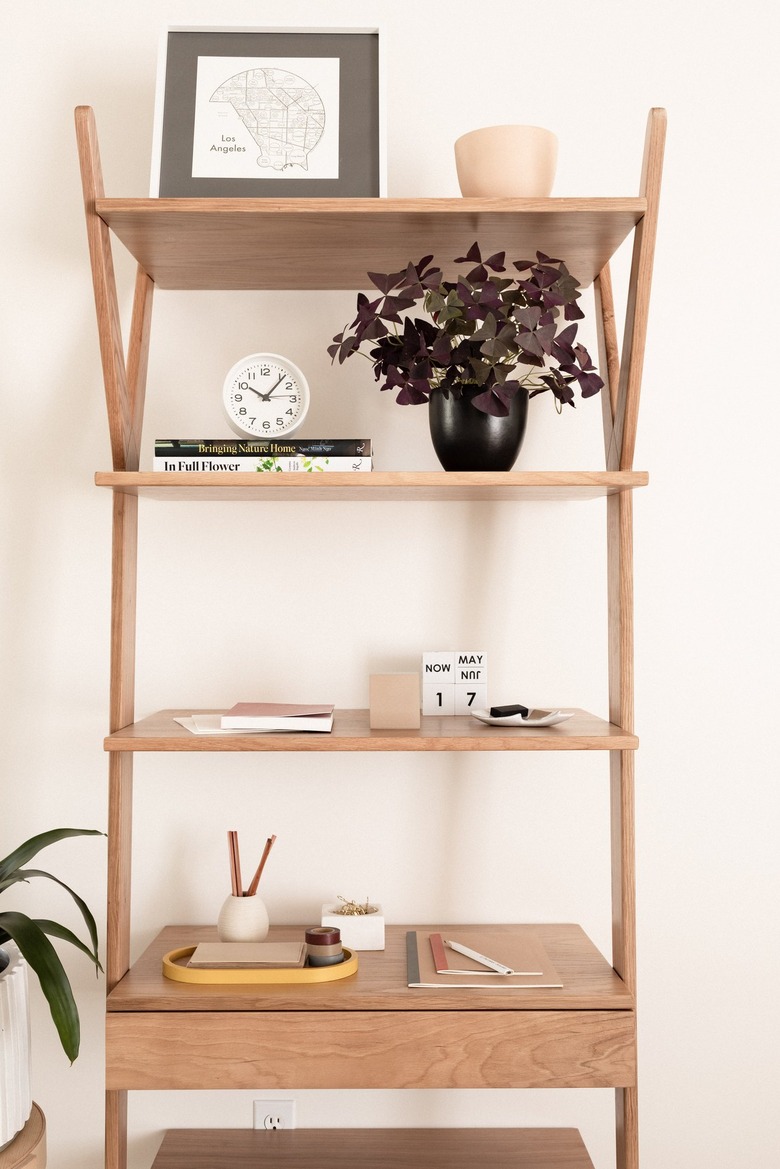 a tall light-wood shelving unit with a lot of clearance between shelves