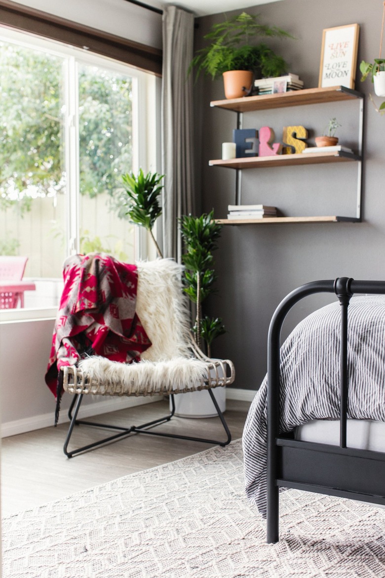 Chair with white shag blanket under shelves