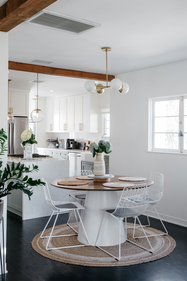 small dining room with round area rug and midcentury lighting