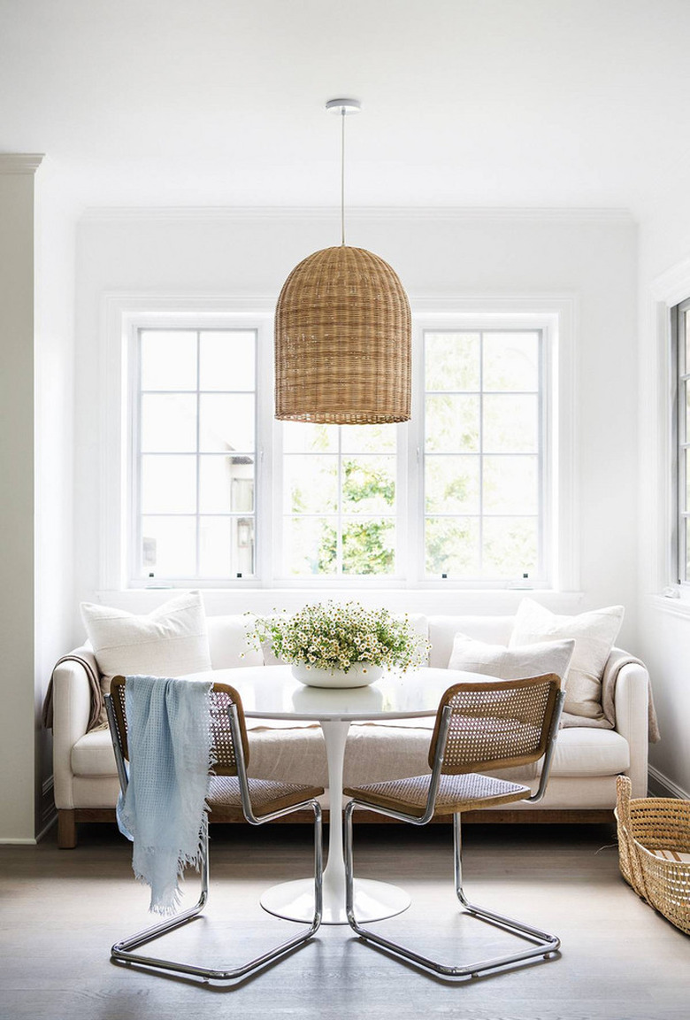 small dining room with caned dining chairs and sofa seating