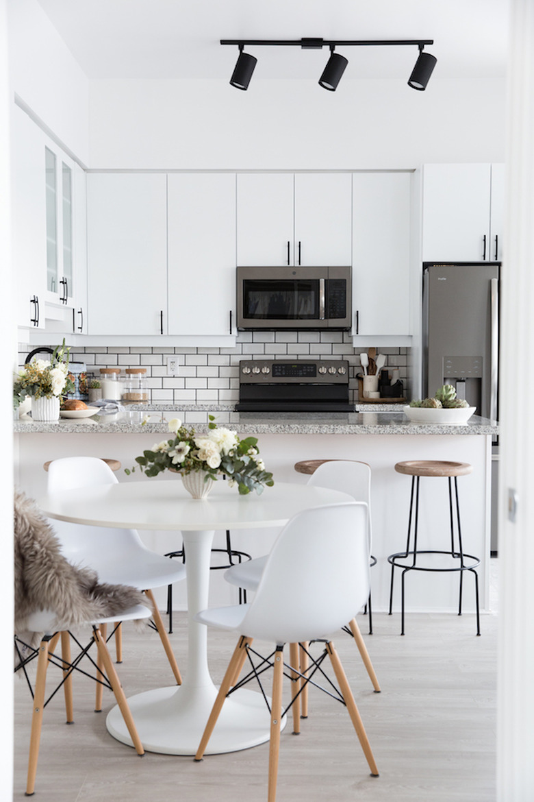 small dining room with round dining tables and white Eames side chairs