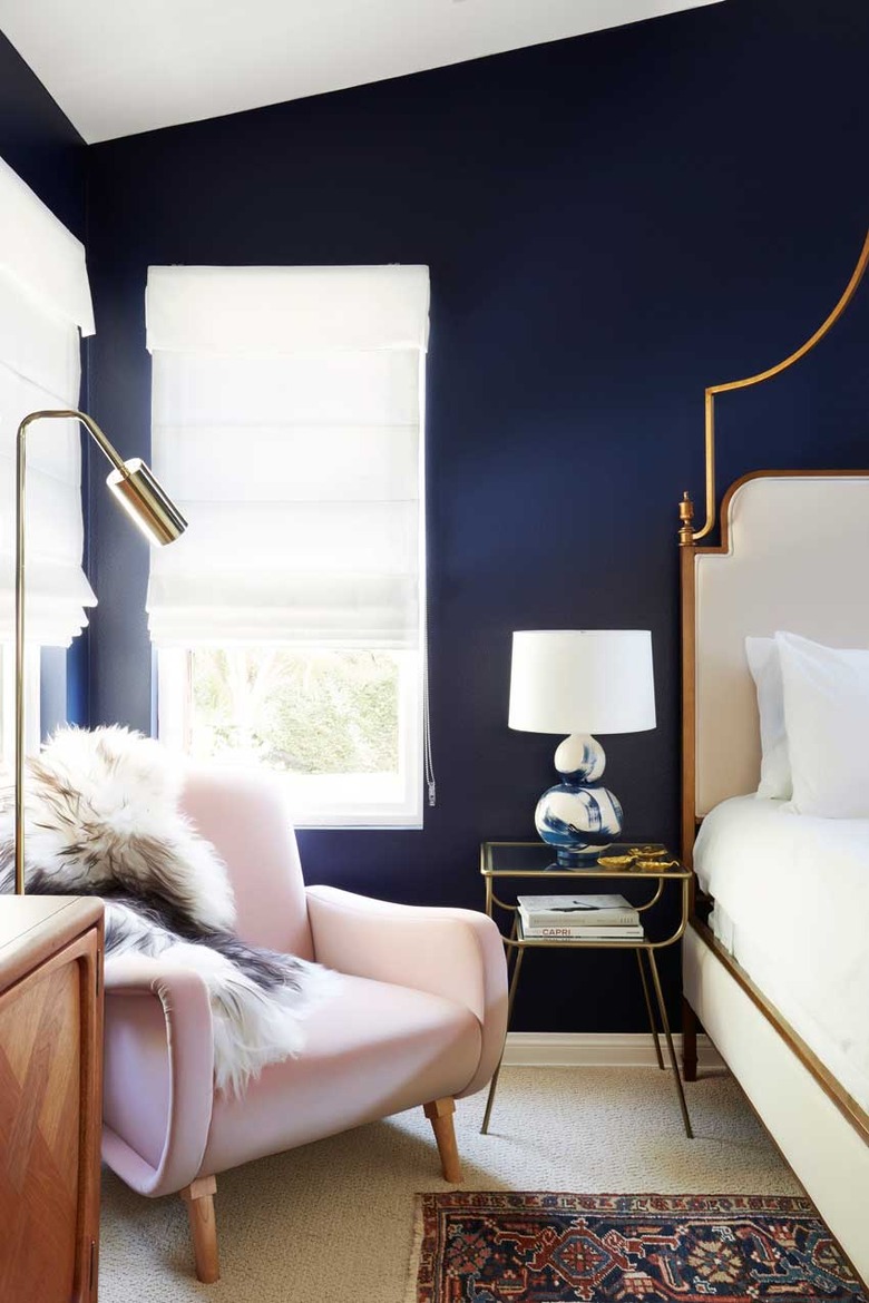 navy blue bedroom with pink velvet lounge chair