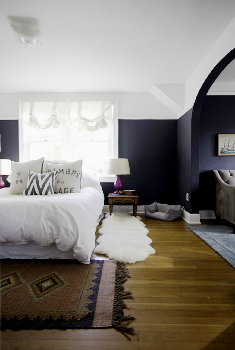 navy blue bedroom with wood flooring and area rug