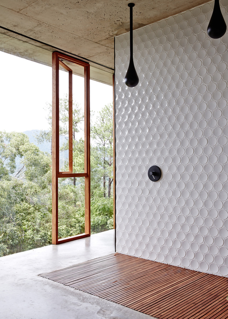 Round tiling in an open-air shower overlooking the trees.