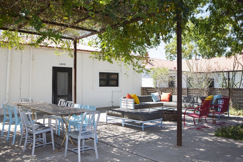 Patio with colorful dining room chairs, pillows and an ivy covered pergola