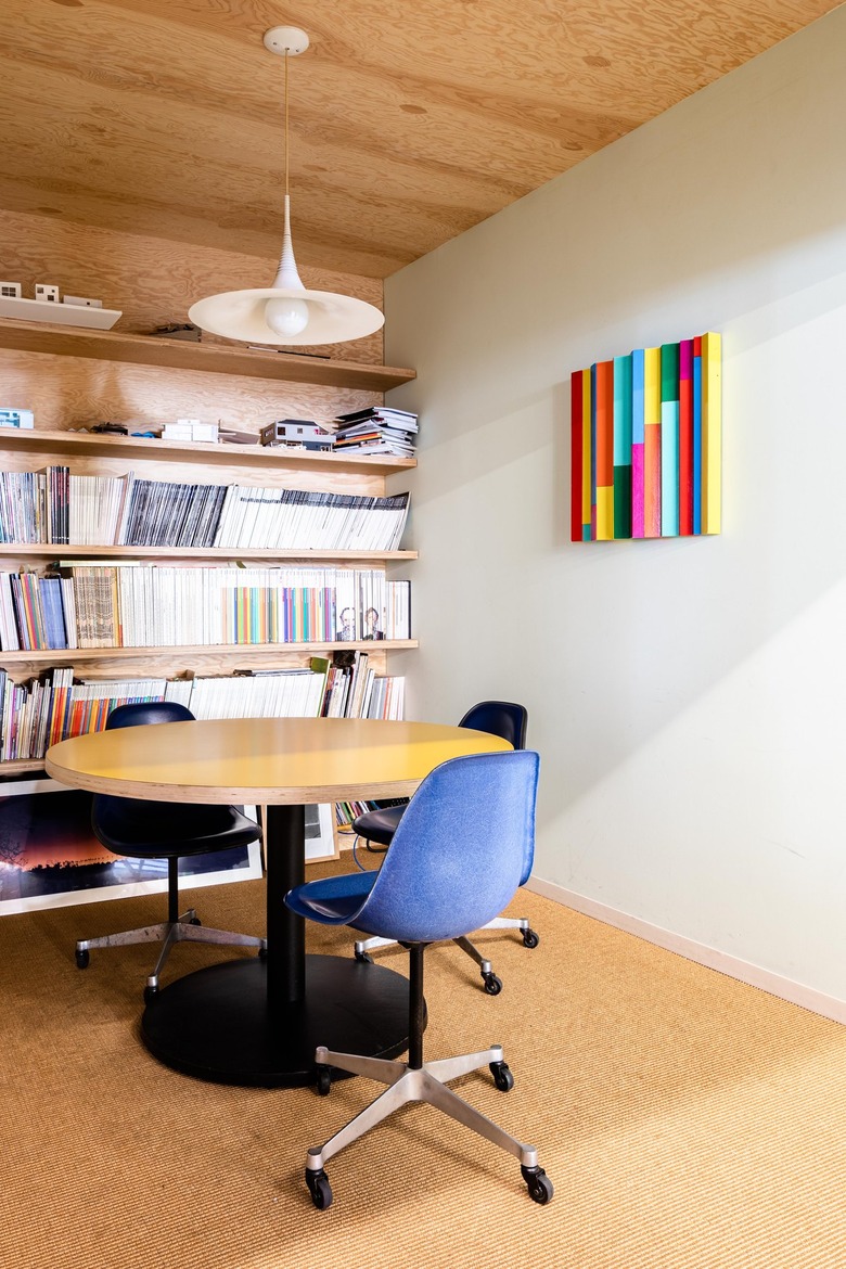 An office with white walls and wood shelving