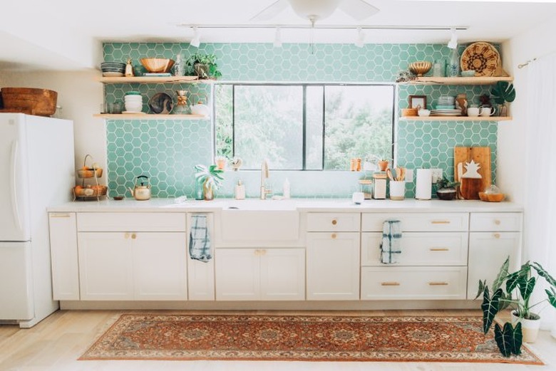 hexagon aqua tile in modern kitchen with white cabinets and farmhouse sink and area rug on floor