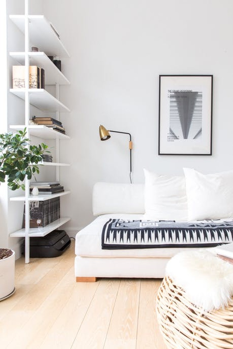 White living room featuring blue and white patterned throw blanket on couch