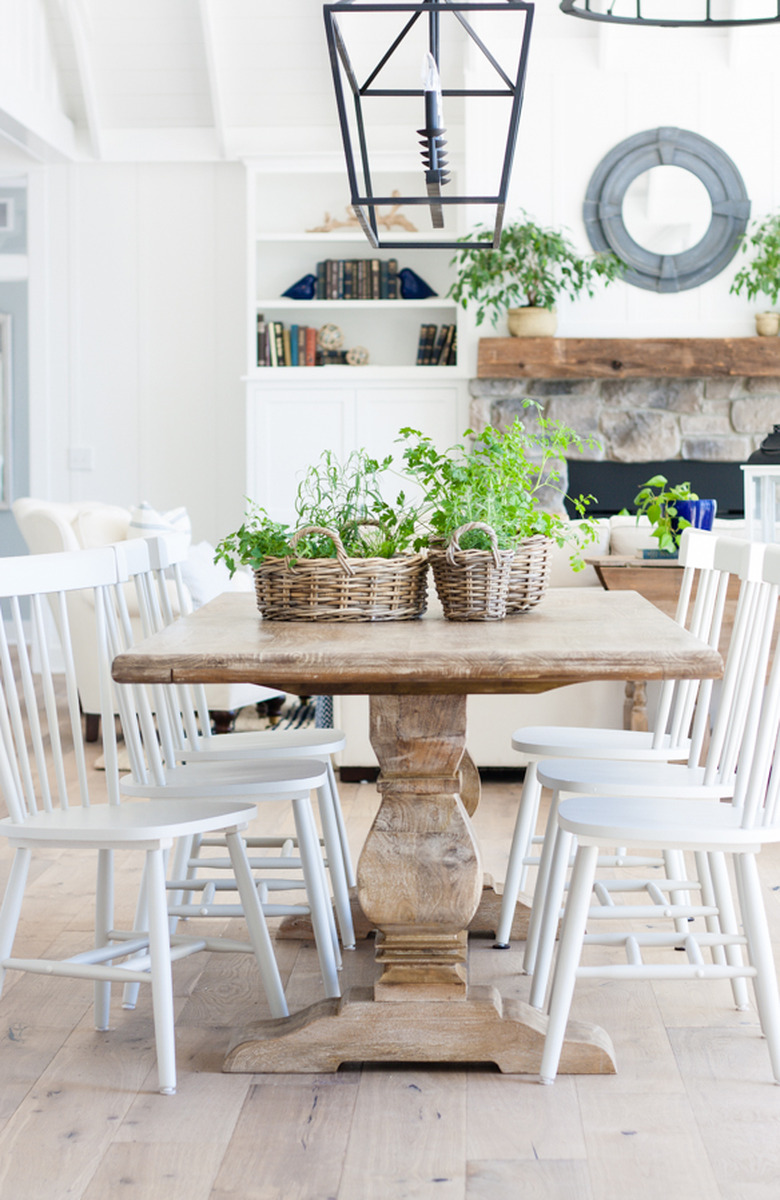 rustic dining room with white chairs and weathered wood table