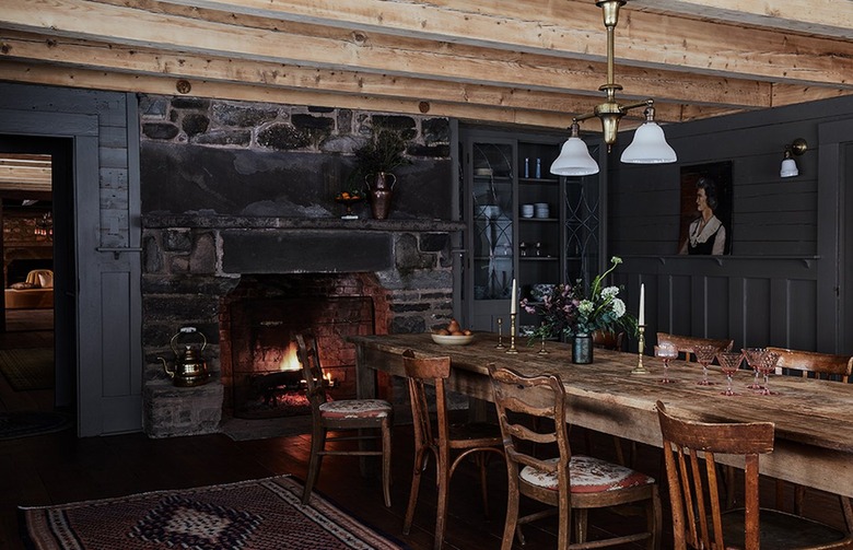 dark rustic dining room with black walls and wooden table