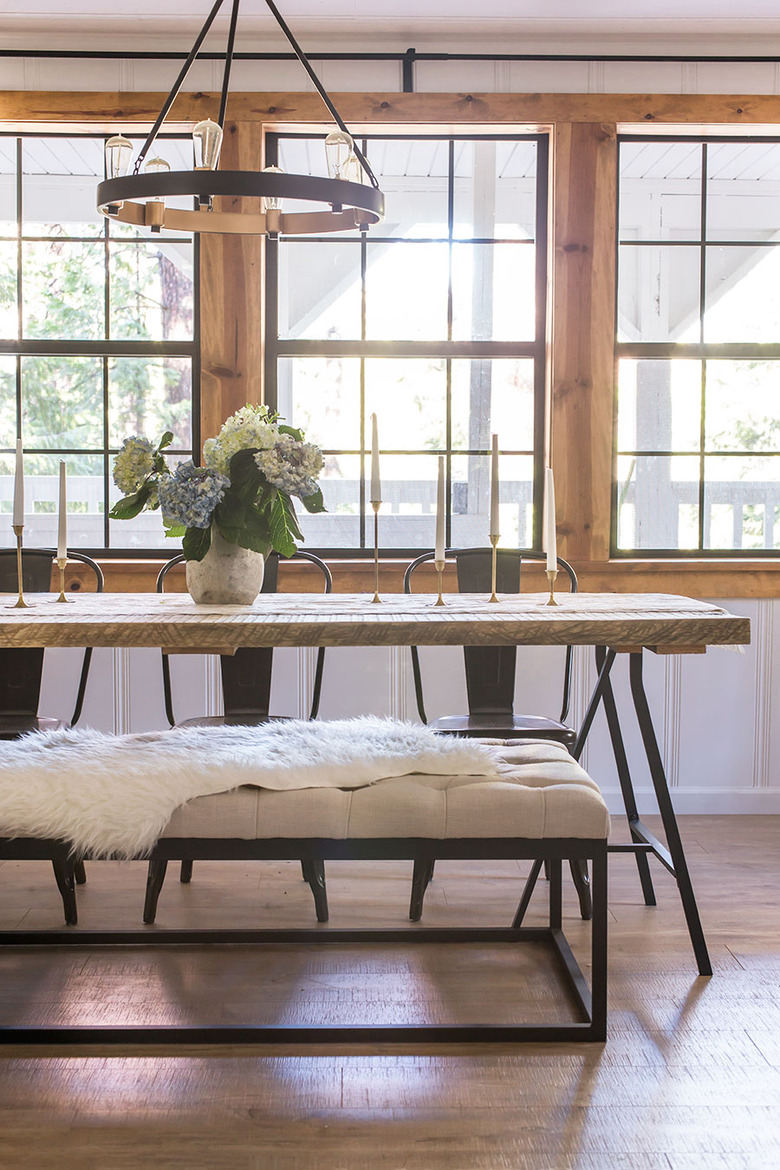 Large windows behind a wood and metal dining table