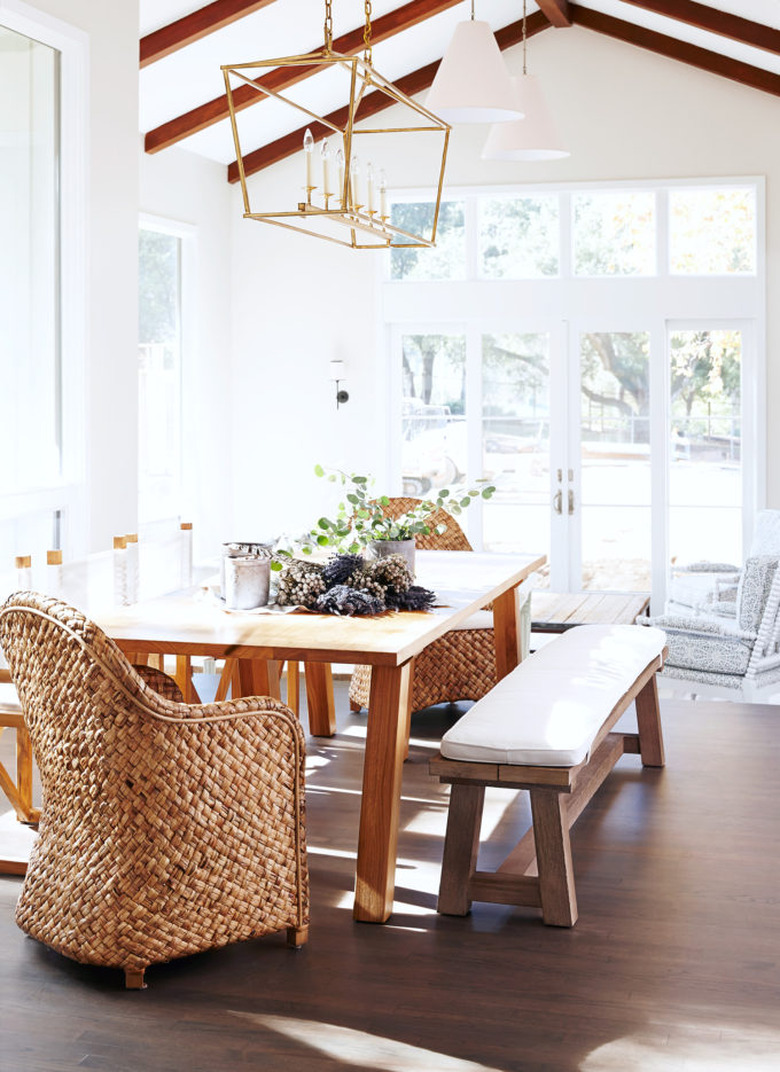 rustic dining room with wood ceiling beams and brass chandeleir