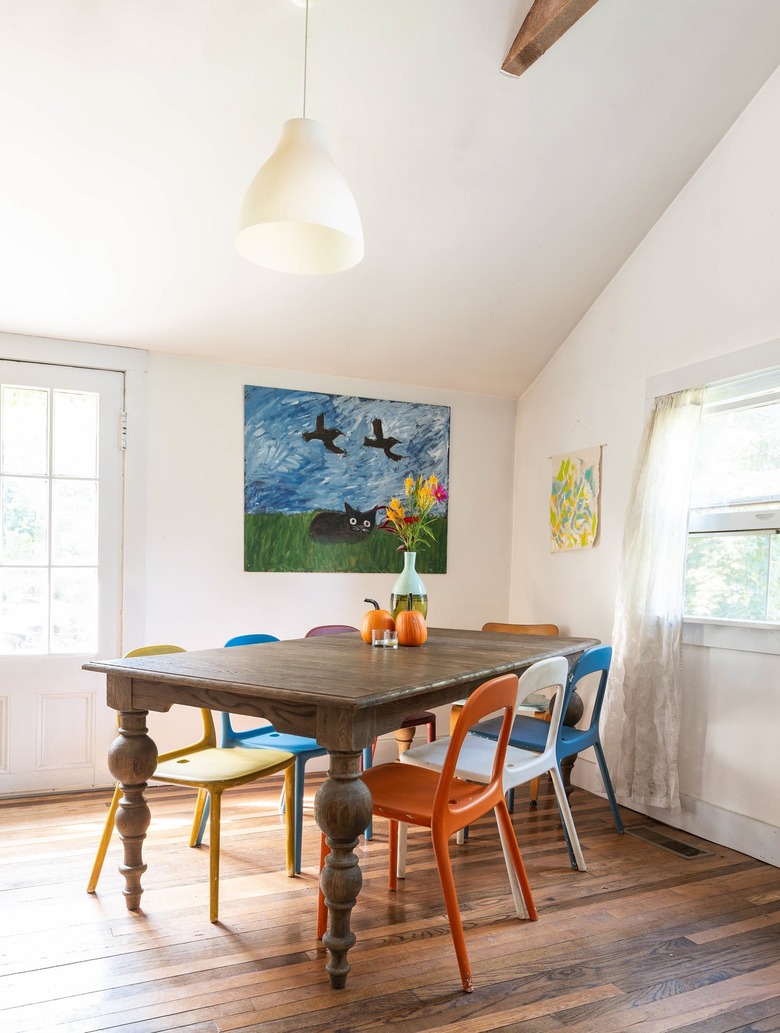 colorful metal chairs surround a rustic wood dining table