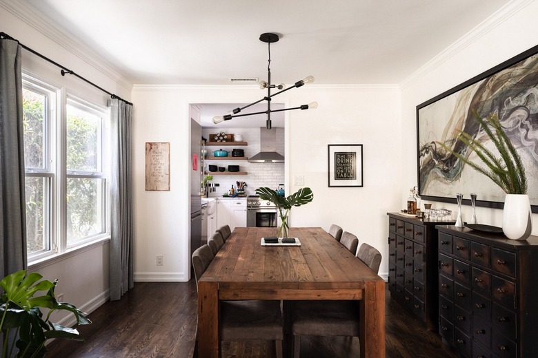 white rustic dining room with wooden table and black pendant light