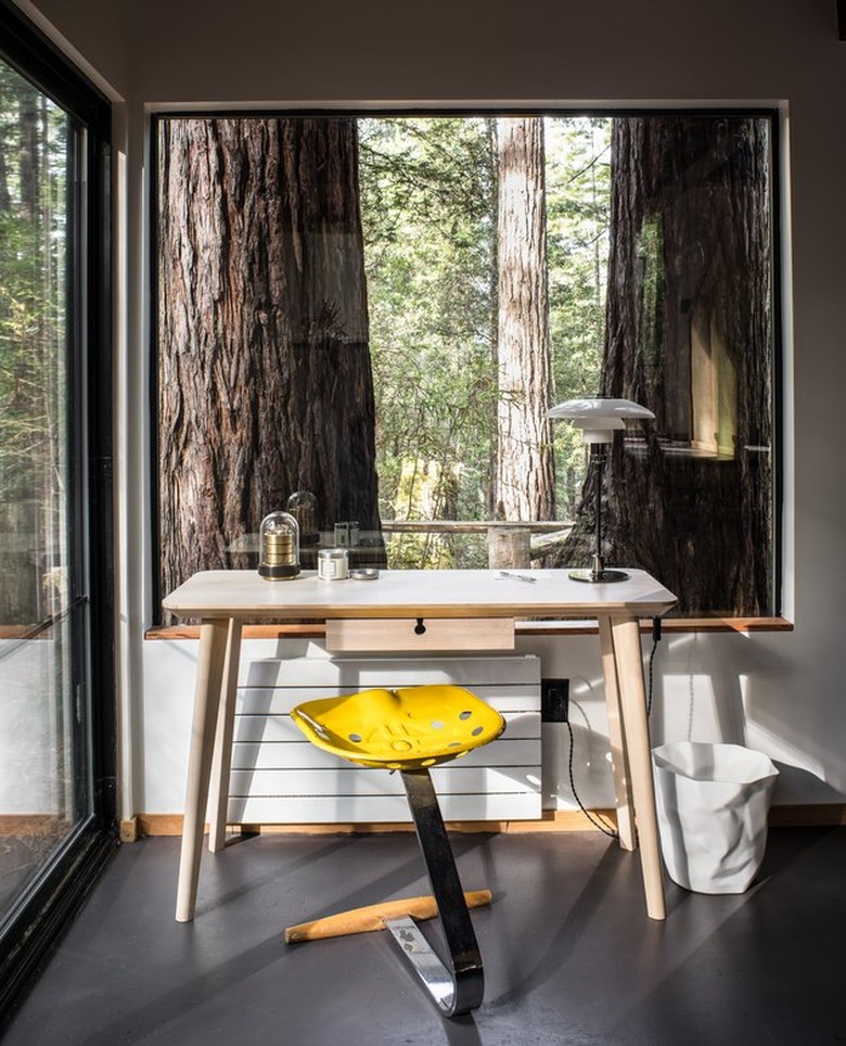 modern desk home office space in forest setting with picture window