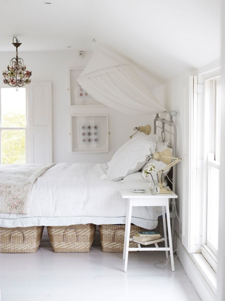 small bedroom with storage baskets below the bed