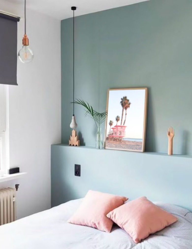 small bedroom with mint green walls and blush colored accents