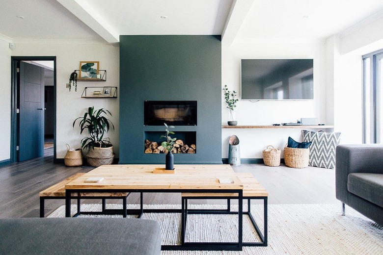 Minimalist living room with accent color fireplace and stacked logs.