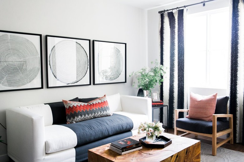 Living room with striped drapes and large artwork.