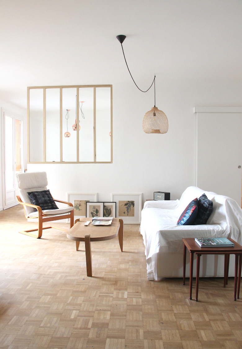 A room with white walls, parquet floors, and sparse decor.