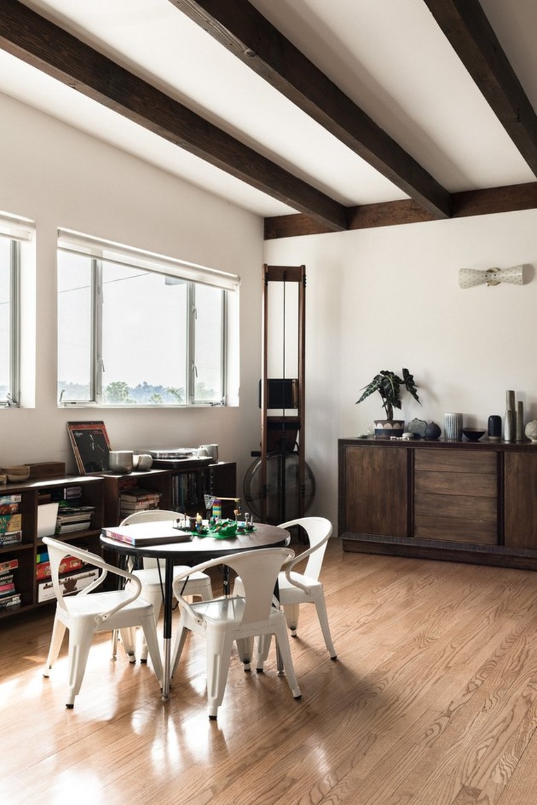 midcentury industrial-style dining area with exposed dark wood beams