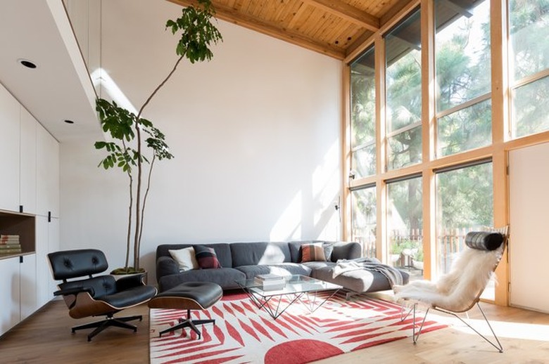 midcentury living room with high, open-beamed ceilings and large wall of windows