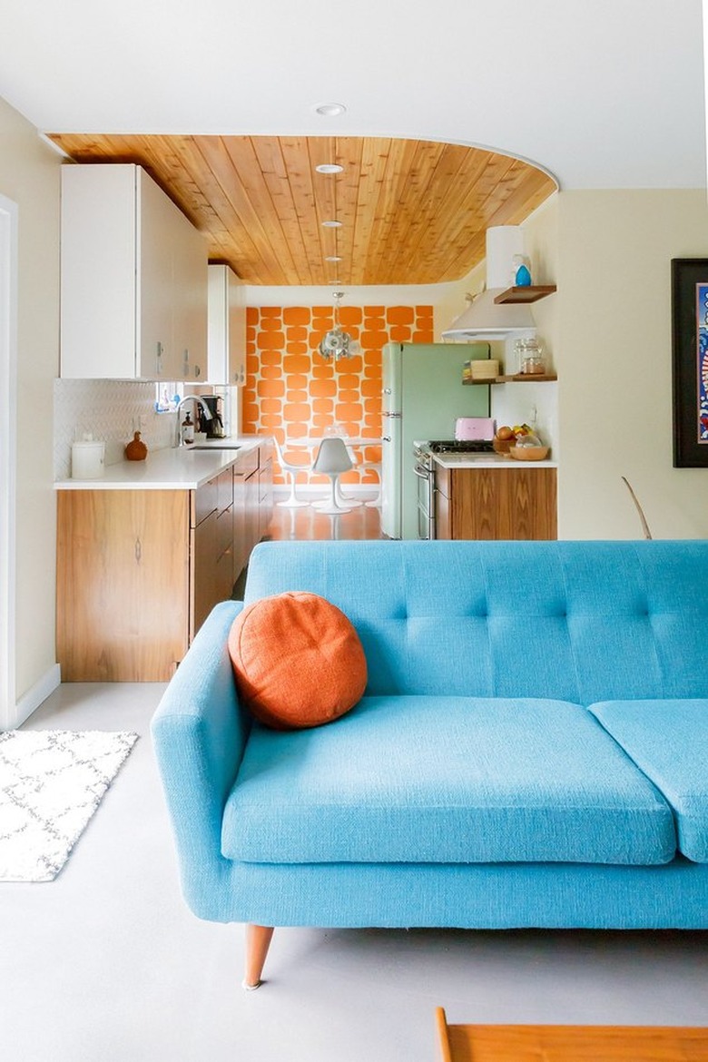 midcentury robin's-egg blue couch with mint smeg fridge in a galley kitchen