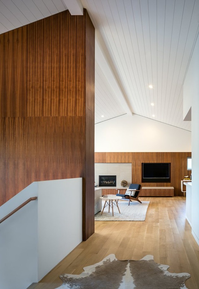 minimal midcentury modern living room and staircase with dark wood paneling