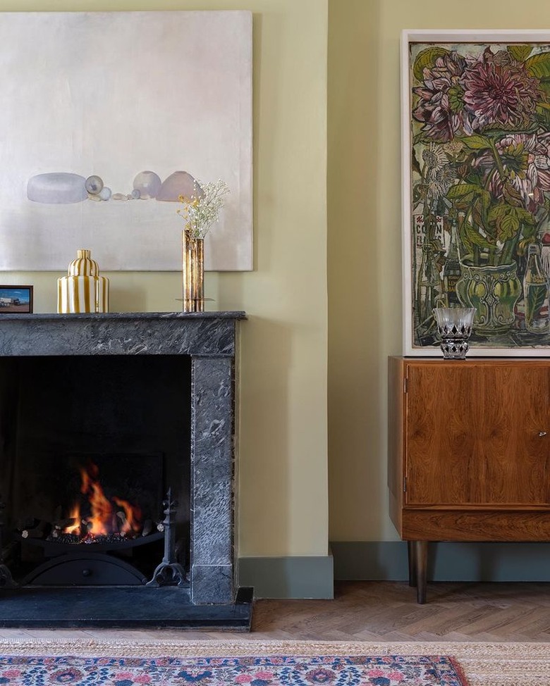 pastel green wall and grey marble fireplace in living room