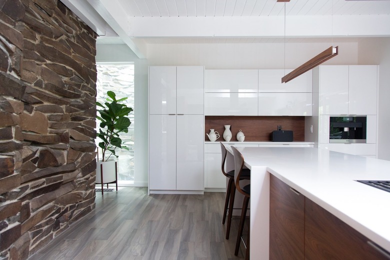 white kitchen with entire stone wall