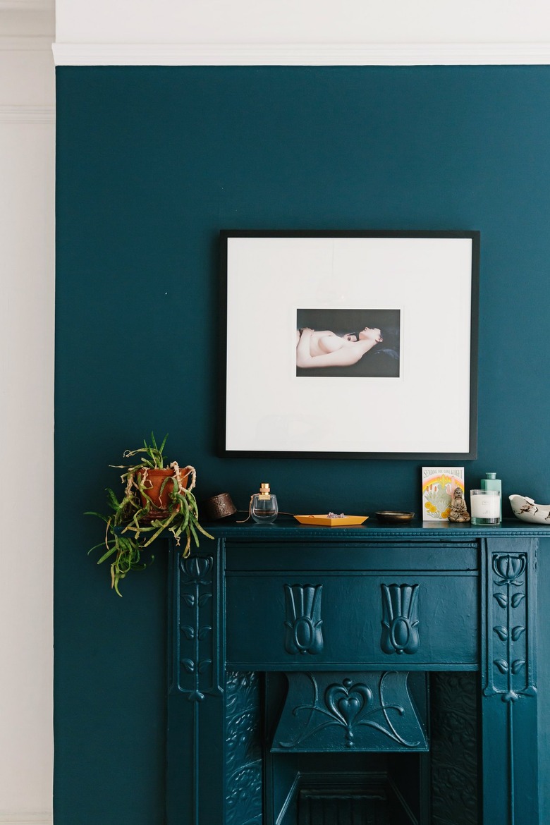 Royal blue mantle and wall against white archway with framed picture and plants