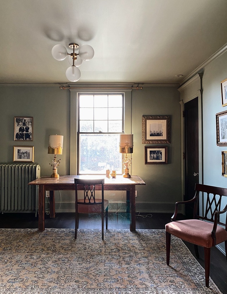 desk area with chair and light green walls with framed art