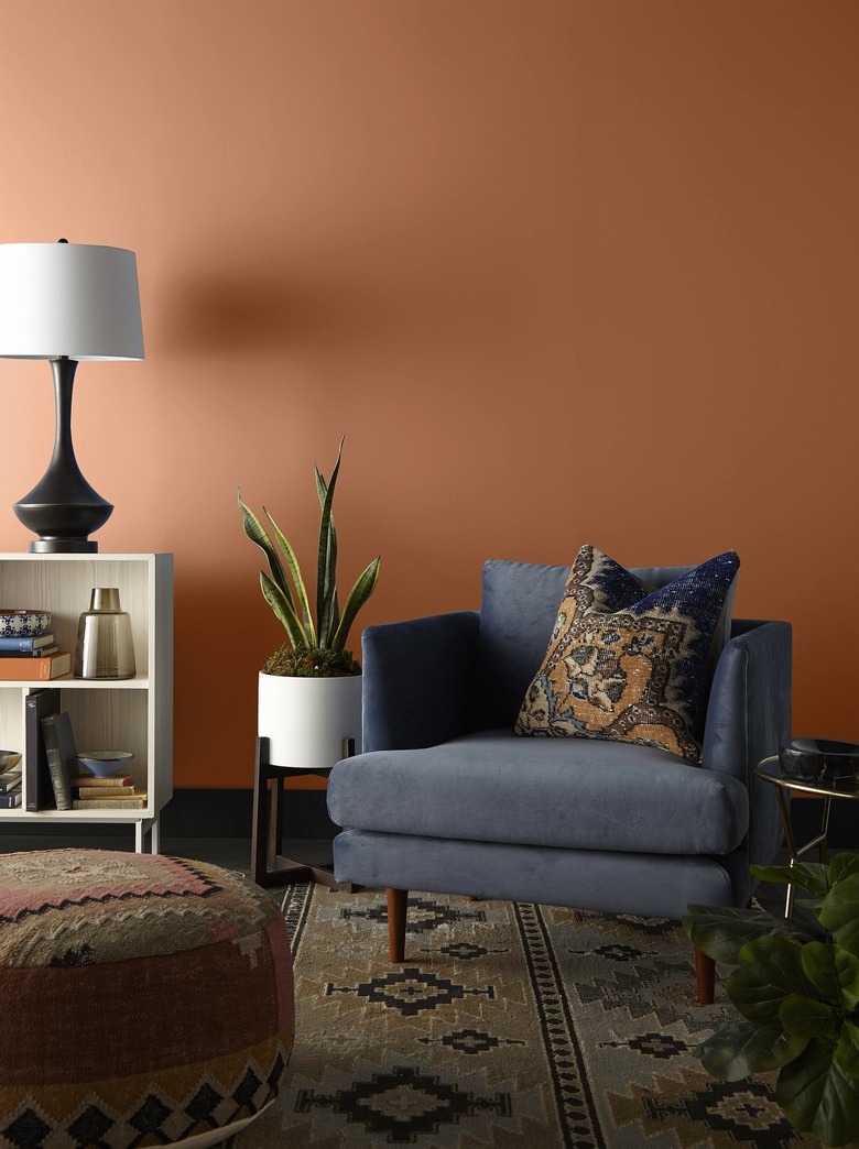 sitting area with blue chair and warm toned wall