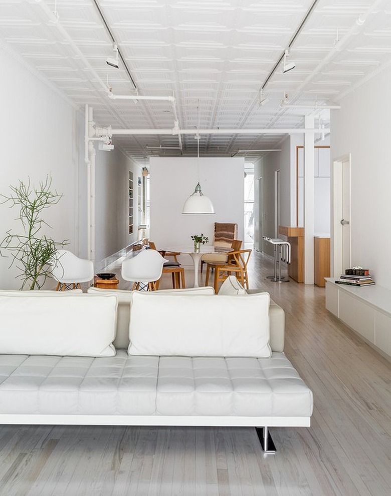 open concept living dining room with Eames plastic chairs and modern couch