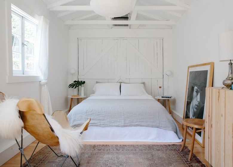 breezy bedroom with white linens and hanging paper lamp