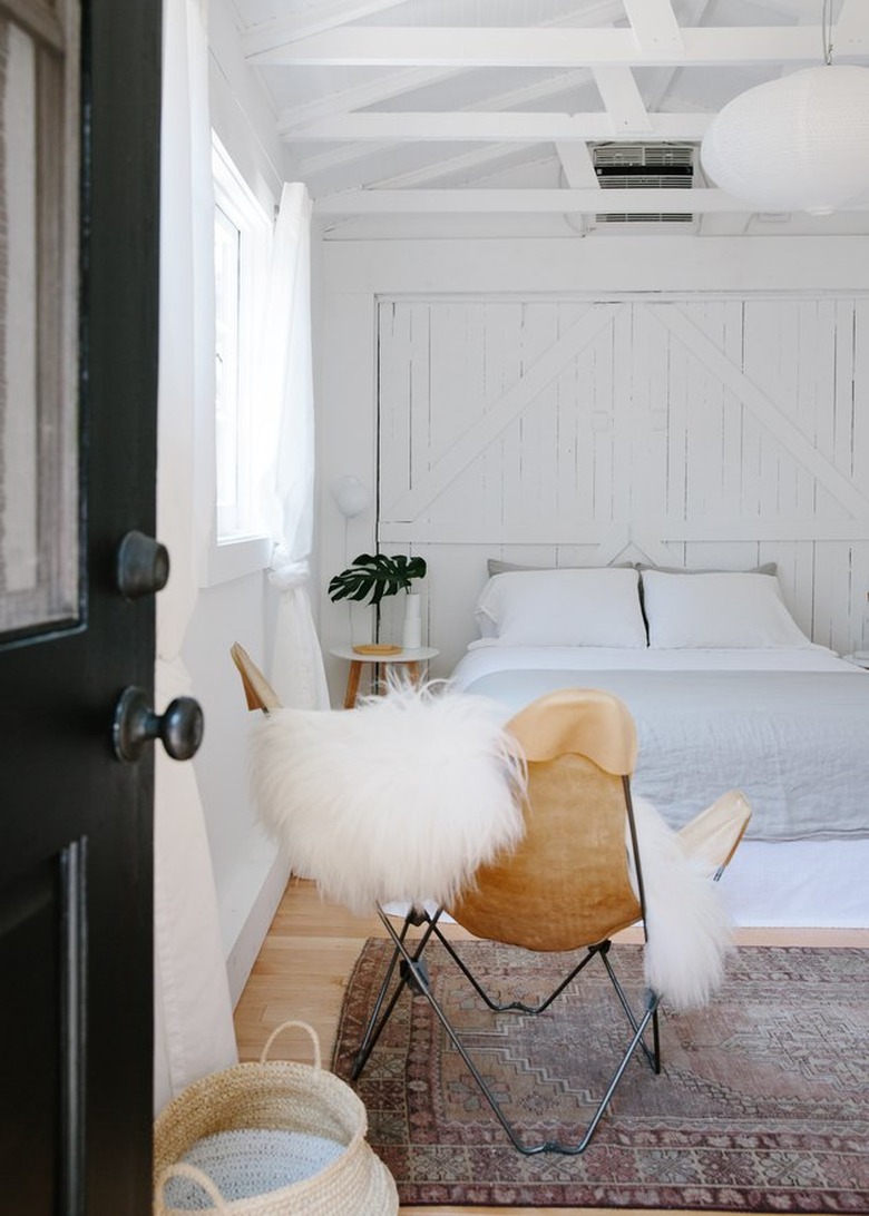 black front door opening to minimal boho bedroom